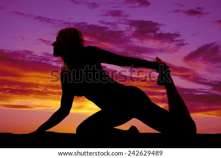 a silhouette of a woman stretching her leg and body.