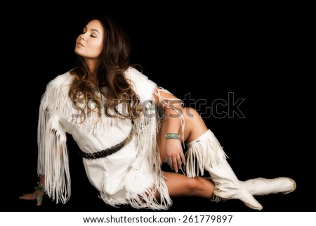 A Native American woman in her traditional dress, looking over her shoulder.