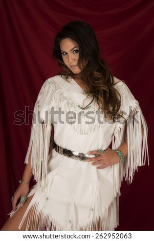 A Native American woman in her Native dress looking.