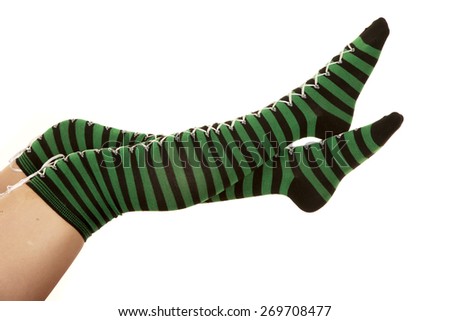 a woman\'s legs up in the air in her black and green striped socks.