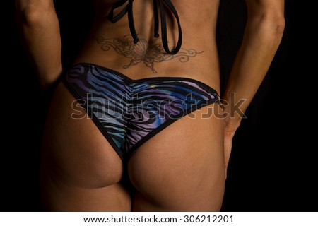 a close up of a woman in her bikini bottom with her tattoo on her lower back.