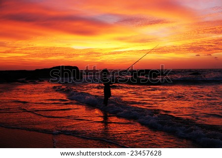 man with fishing rod on coastline at sunset time