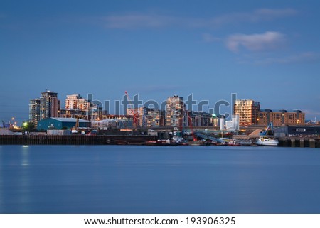 London, UK - August 4 2011: Mix of industries and residential buildings on bank of Thames in Newham, London.