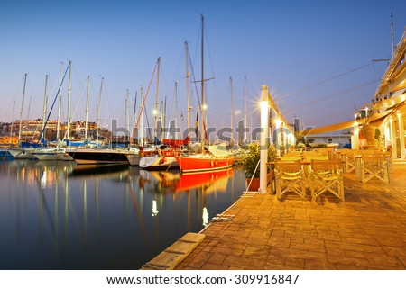 Athens, Greece - July 28 2015: Sail boats at the coffee shop of the yacht club in Mikrolimano marina in Athens, Greece.