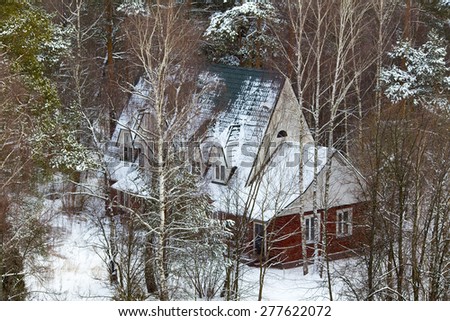 Wooden cottage in winter forest high angle view