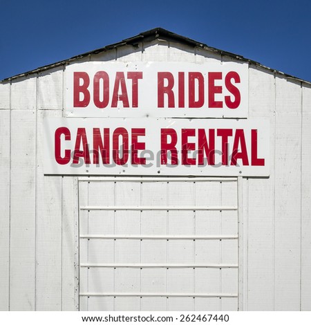 Boat Rides and Canoe Rental Sign on a White Building