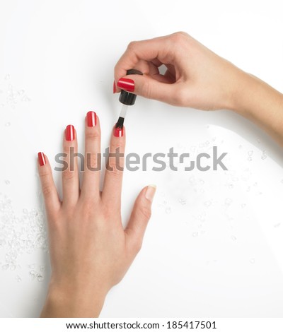 woman hands application nail polish on a white surface with crystals