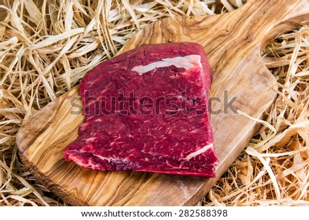 British Beef Flat Iron steak on cutting board and straw.