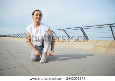 Similar – Foto Bild Junge ethnische Sportlerin läuft auf dem Laufband, während sie in einem modernen Fitnessstudio trainiert