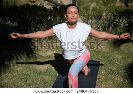 Similar – Image, Stock Photo Calm woman in Warrior pose on yoga mat