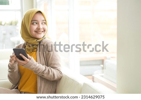 Similar – Image, Stock Photo Positive Muslim woman using smartphone on embankment