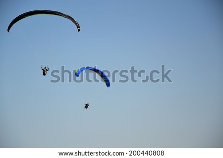 jump with a parachute (parapant ) on blue sky background