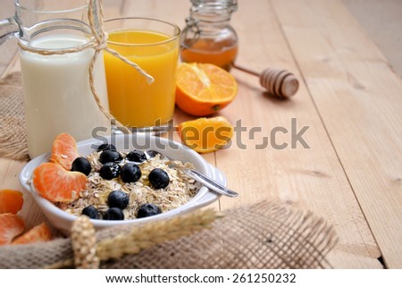 breakfast of cereal with blueberries, milk and honey
