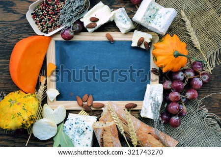 frame of cheese, grapes and pumpkin, background for text or logo,cooking concept