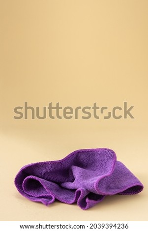 Purple microfiber cloth for washing on a neutral beige background, cleaning concept Imagine de stoc © 