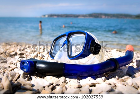 Blue diving goggles on sea beach
