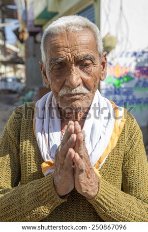 Chanderi, India - January 5, 2015: Old Indian man greeting with his palms together in a namaste gesture. Namaste is spoken with a slight bow and hands pressed together, palms touching.