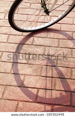 shadow from bike on red brick road in sun light