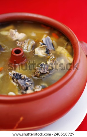 close up chinese chicken and vegetable soup in red bowl