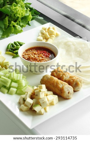 pork and vegetable vietnamese and spicy sauce in white ceramic dish