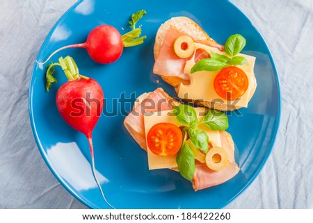 small sandwiches with smoked ham, cheese and cherry tomato