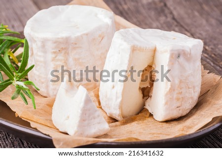 Two french goats cheeses on wooden background