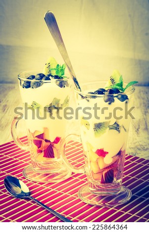 vintage photo of Fresh fruit in cream. A dessert from fruit and cream