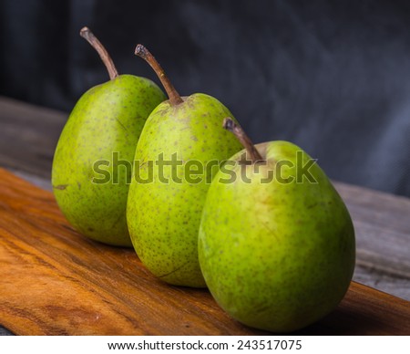 Pears on wooden cutting board and ancient wooden table