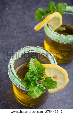 Herbal Tea with a fresh lemon balm leaves on a black table