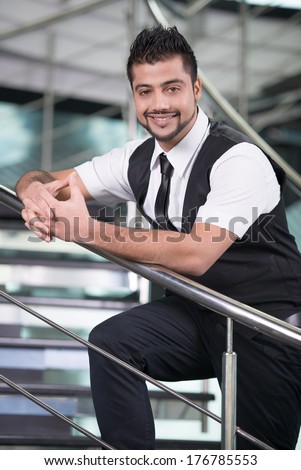 Young Asian Indian businessman standing on office background