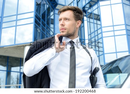 Portrait of a young detective with a gun on a background of the business center