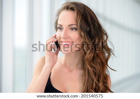Business woman at work. Confident young business woman talking on the phone while sitting at her working place