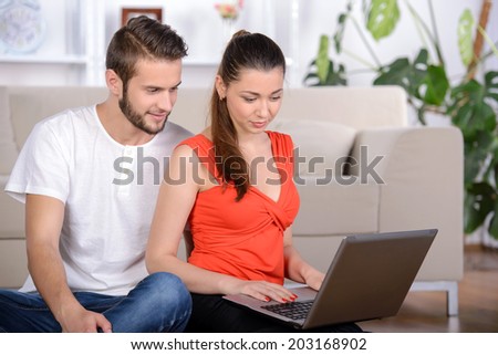 Young people lying on the floor at home and using laptop at home