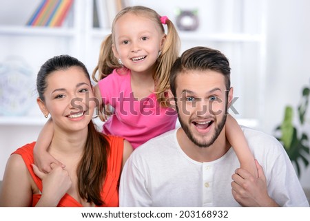 Happy family with a child sitting on the couch at home