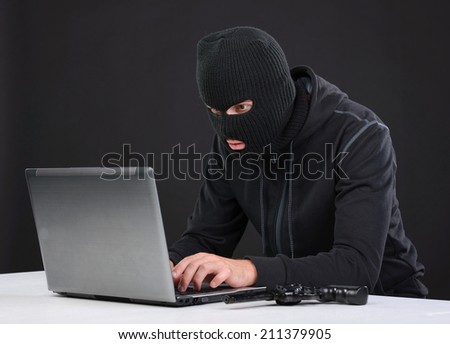 Computer hacking. Close-up of frustrated criminal using computer