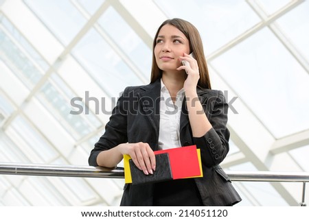 Business woman in business trip with bag and speaking mobile