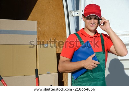 Smiling young male postal delivery courier man in front of cargo van delivering box