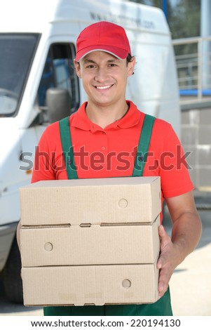 Smiling young male postal delivery courier man in front of cargo van delivering boxes