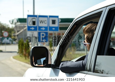 Man in his car stops at petrol station