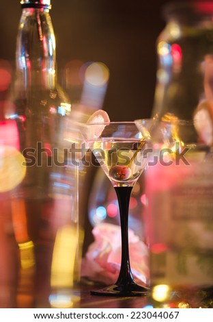 Different alcohol drinks and cocktails on bar. colored light