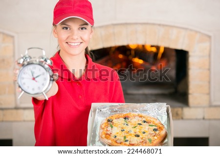 Beautiful delivery woman with delicious pizza in pizza box and clock.