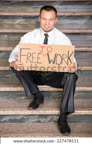 Fired businessman is searching for a job, sitting on the stairs.