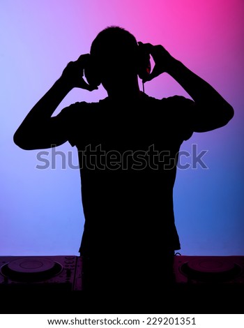 Silhouette of a man. Portrait of a young man with earphones on the colored background.