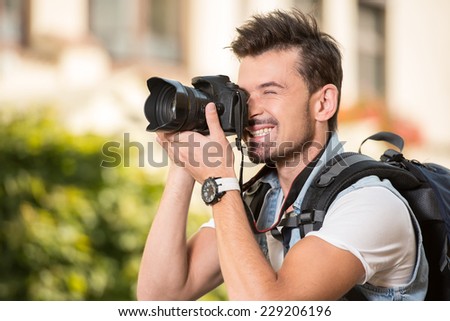 Portrait of happy, smiling man, tourists with camera in the city.