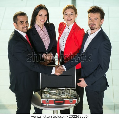 Portrait of business people are shaking hands, entered into an agreement, suitcase with money.
