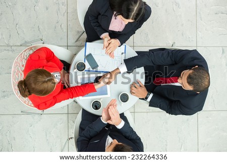 Above view of several business people are planning work at round table.