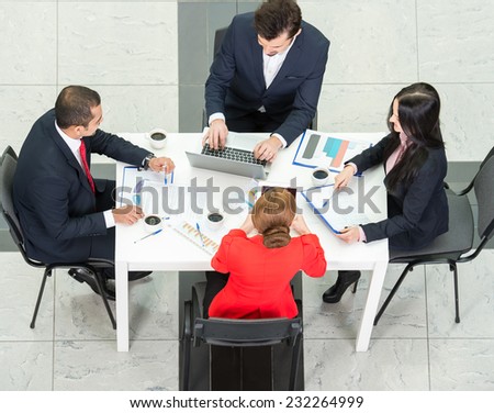 Above view of business team are sitting around table and working.