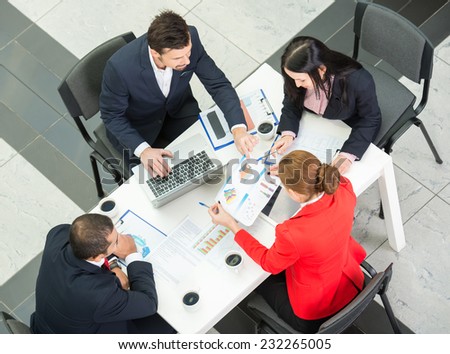 Above view of business team are sitting around table and working.