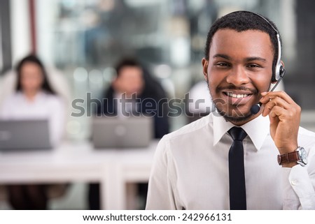 Portrait of happy smiling customer support phone operator at workplace.