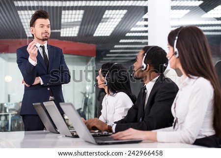 Manager is explaining something to employees in a call centre